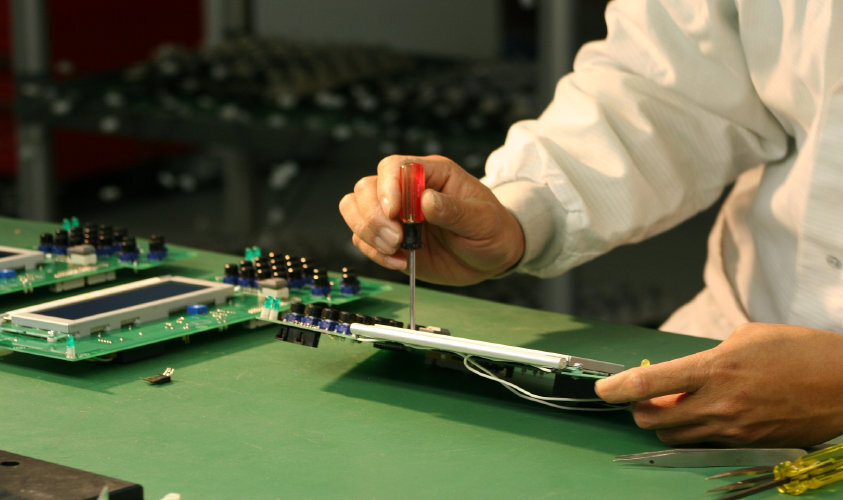 HPN Electronics technician assembling and testing a circuit board